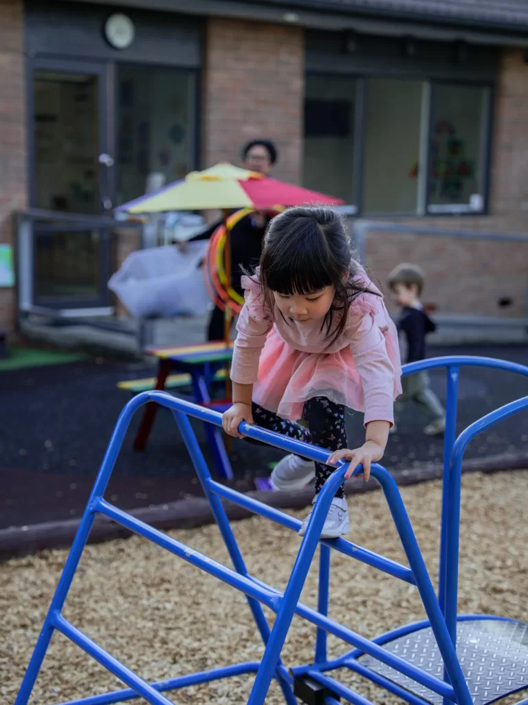 Kinderworld Early Learning Centre child climbing on playground equipment during outdoor activity time